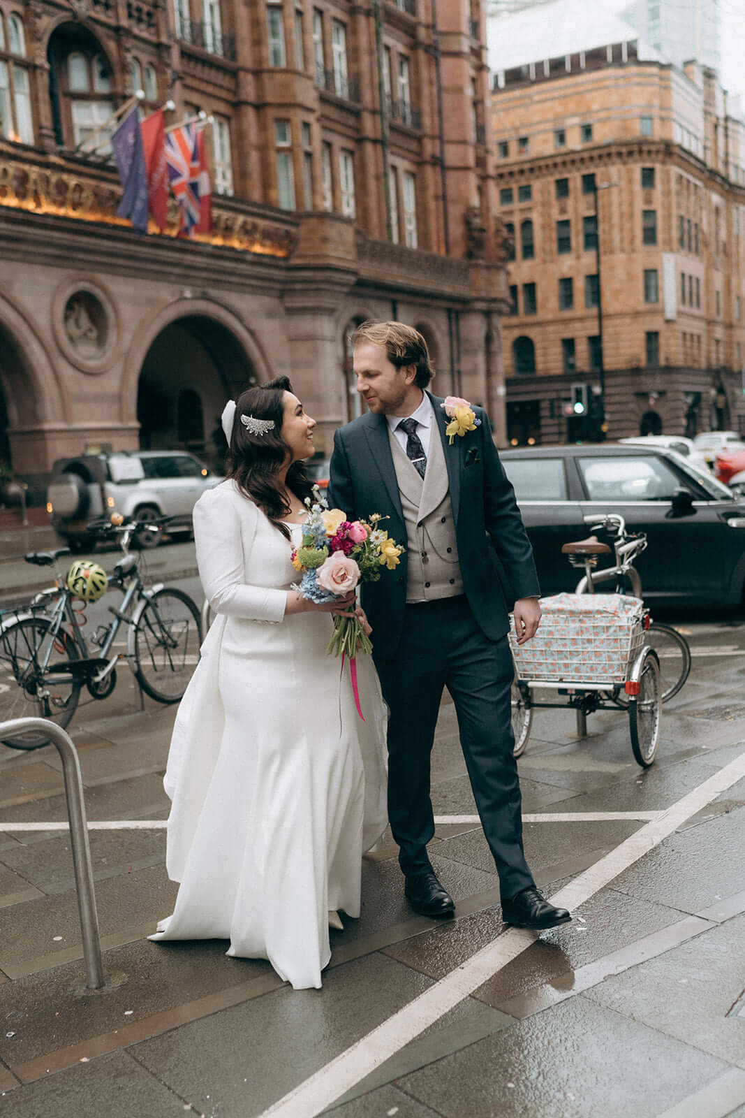 spring wedding bride and groom outside the midland in Manchester with their bridal bouquet and buttonhole