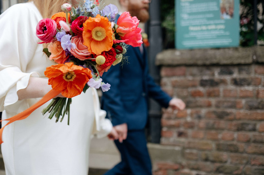 Bright, colourful, luxury seasonal and wild wedding flower bouquet in oranges, pinks and yellow. Icelandic Poppies.