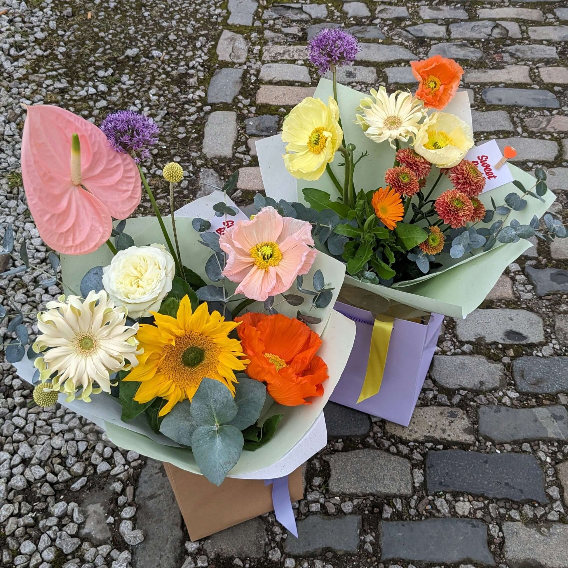 two modern fresh flower bouquets in pastels and bright colours, including icelandic poppies 